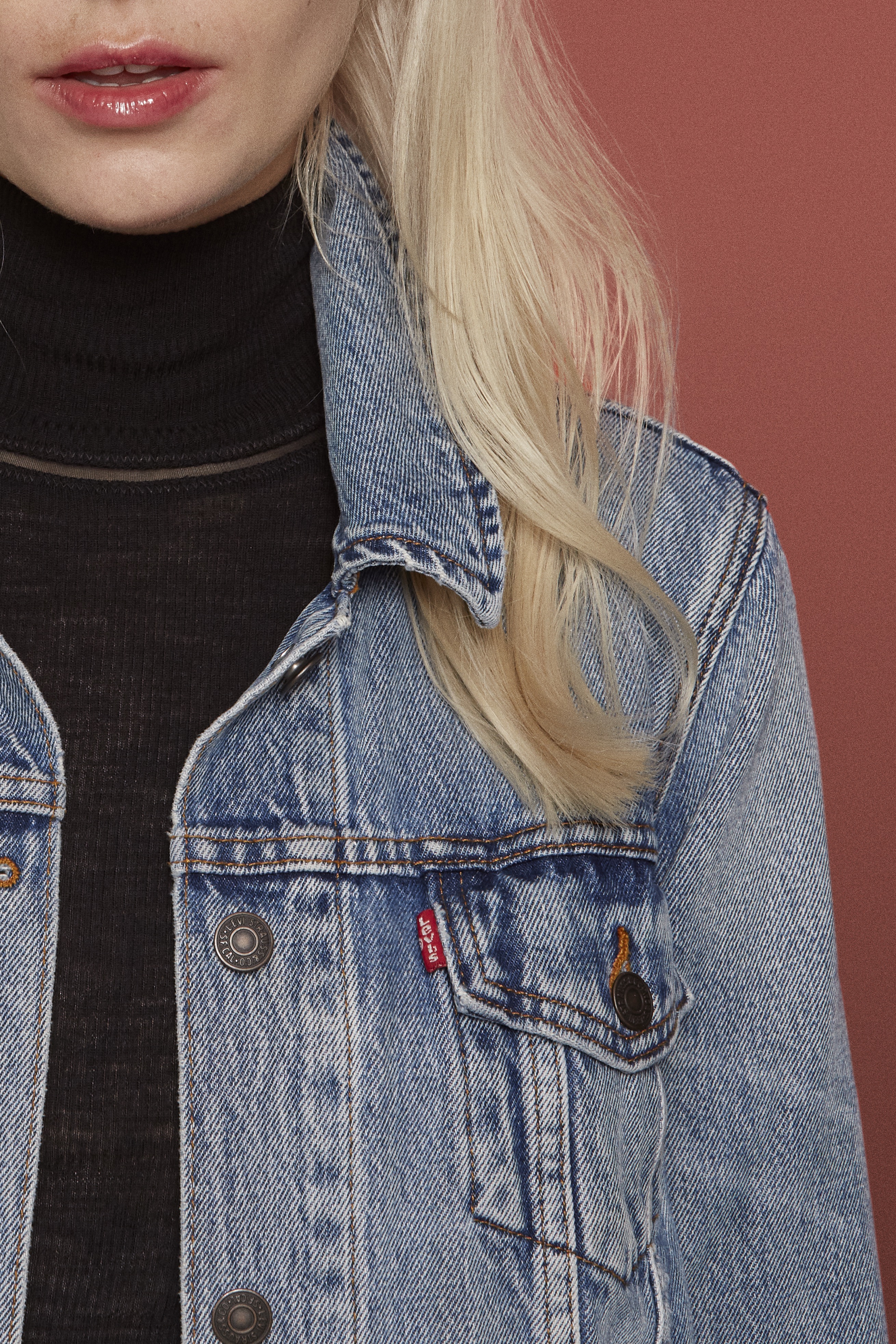 Woman with blonde hair, denim jacket, and black turtle neck.