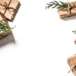 image of gift boxes wrapped in plain brown wrapping paper with twine ribbon and a pine leaf