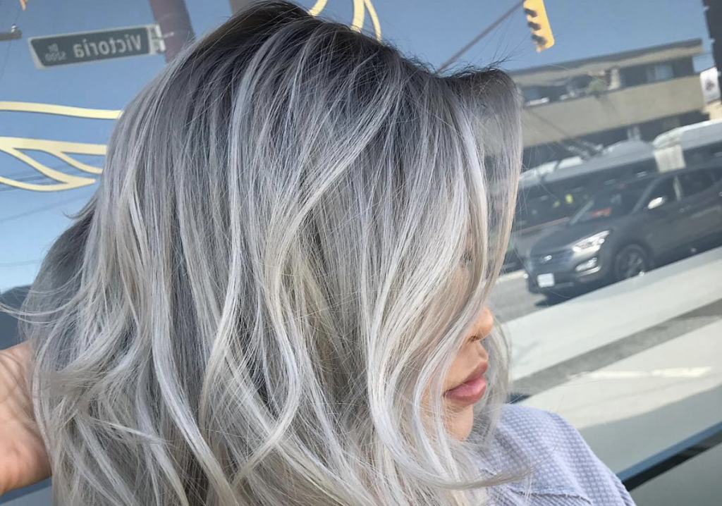 Woman with silver hair posing after a haircut