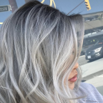 Woman with silver hair posing after a haircut