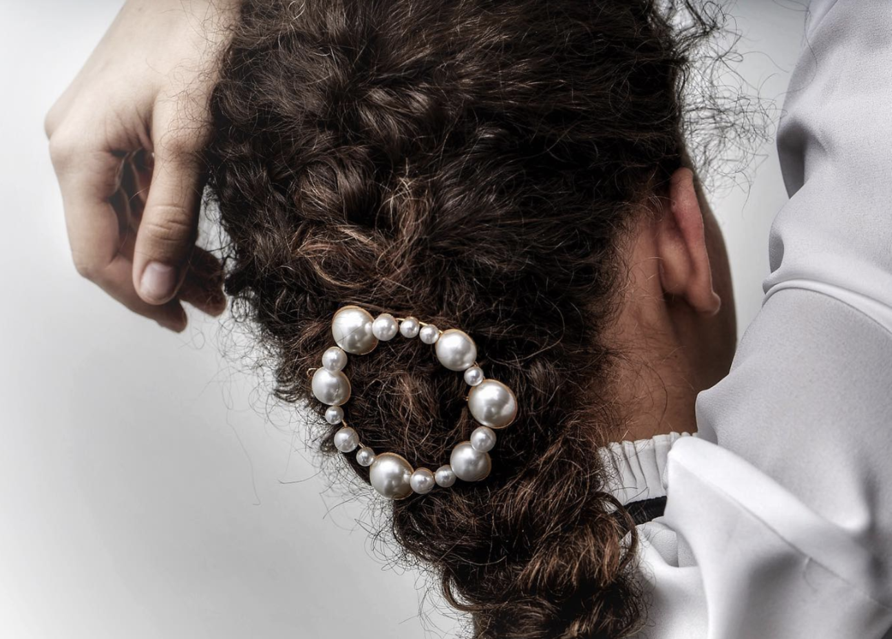 Pearl hair barrette featured in a curly, brunette braid