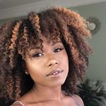 Woman with a highlighted twist out looking at the camera