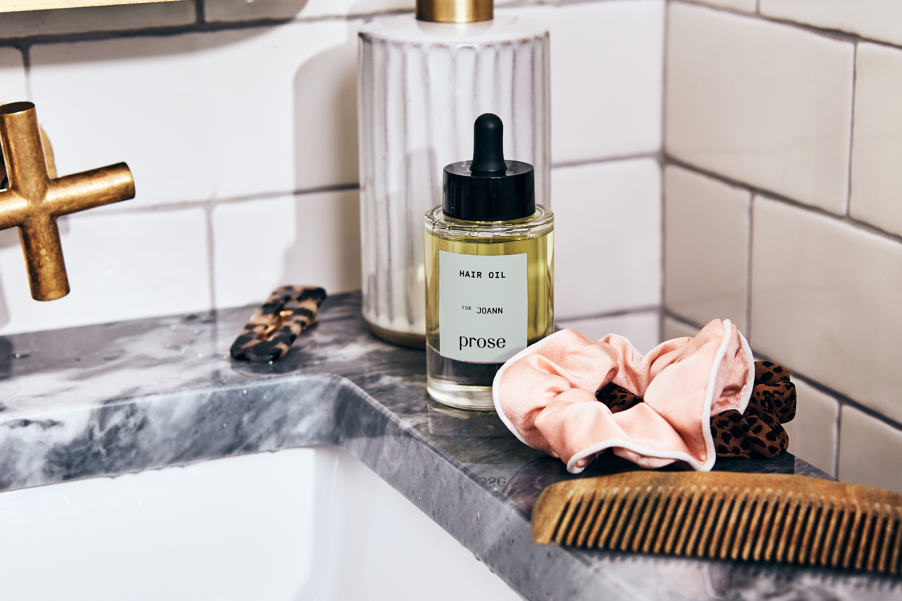 prose custom hair oil sits on a marble sink
