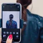 woman takes a photo of a woman with brown hair with an iphone