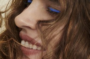 woman with brown curly hair smiles