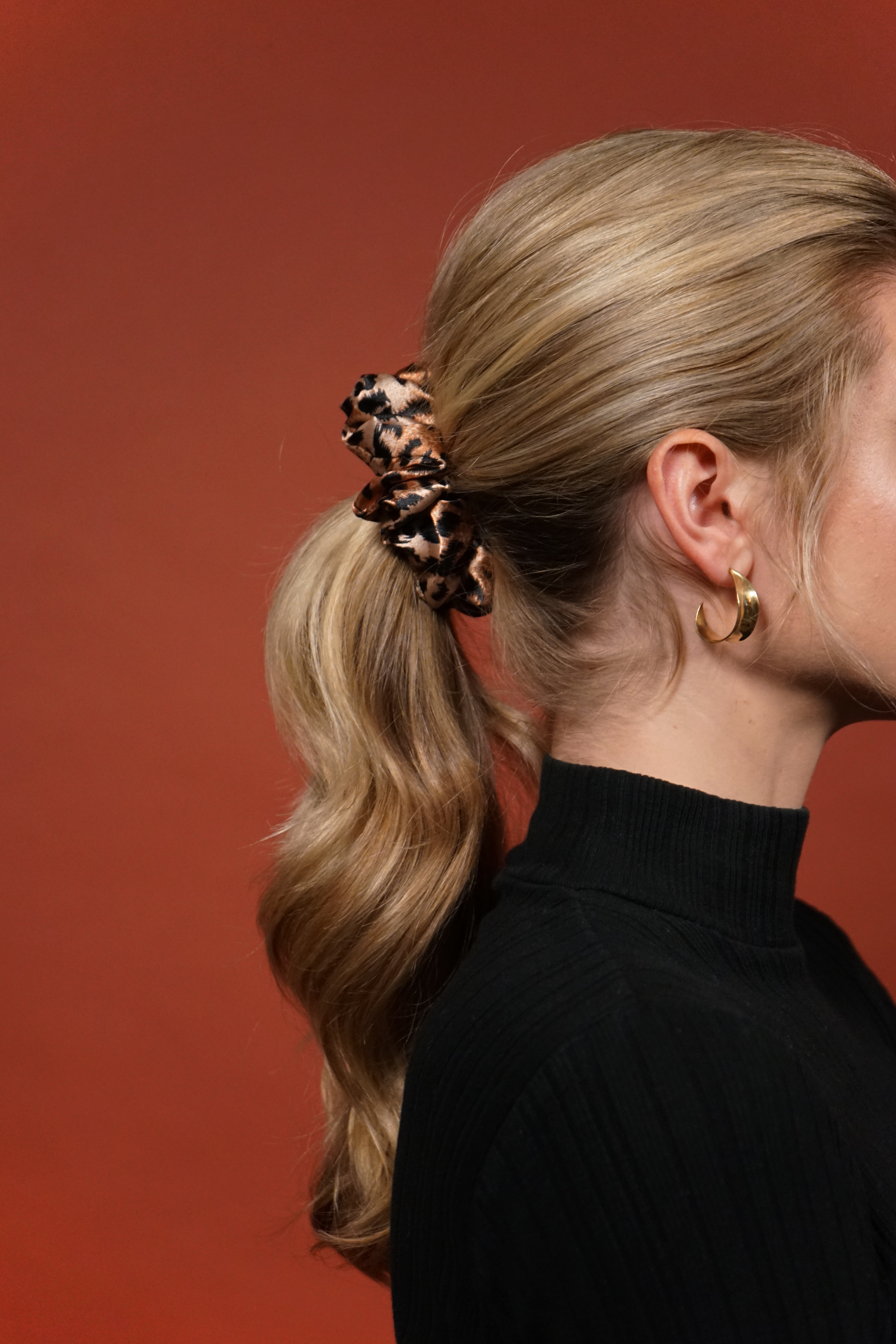 woman with long, blonde hair pulled up in a cheetah scrunchie