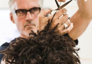 hairstylist cutting man's curly hair