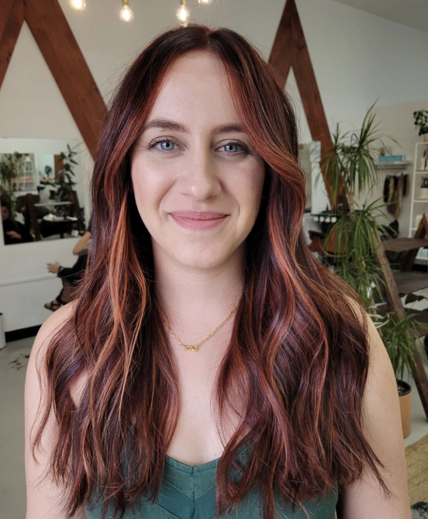 woman with face framing red balayage hair color