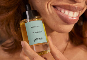 women smiling holding a hair oil