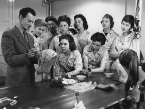 13th March 1957:  A BBC make-up man teaches a batch of new recruits the art of dressing hair for television appearances.  (Photo by William Vanderson/Fox Photos/Getty Images)