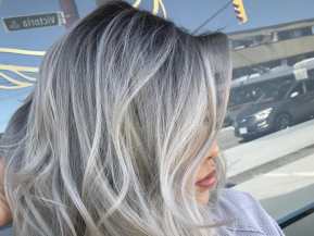 Woman with silver hair posing after a haircut