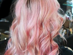 woman with pink hair that's been curled at a salon