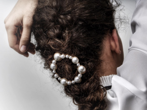 Pearl hair barrette featured in a curly, brunette braid