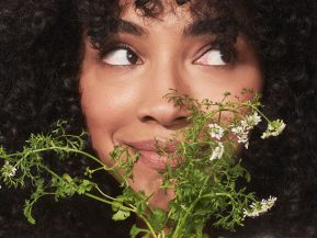 woman with curly hair holds flowers