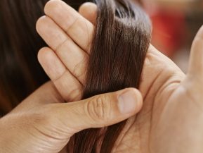 Stylist examining a clients hair.