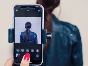 woman takes a photo of a woman with brown hair with an iphone