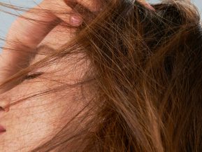 woman running her fingers through her straight hair