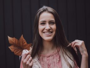 girl smiling while holding a leaf